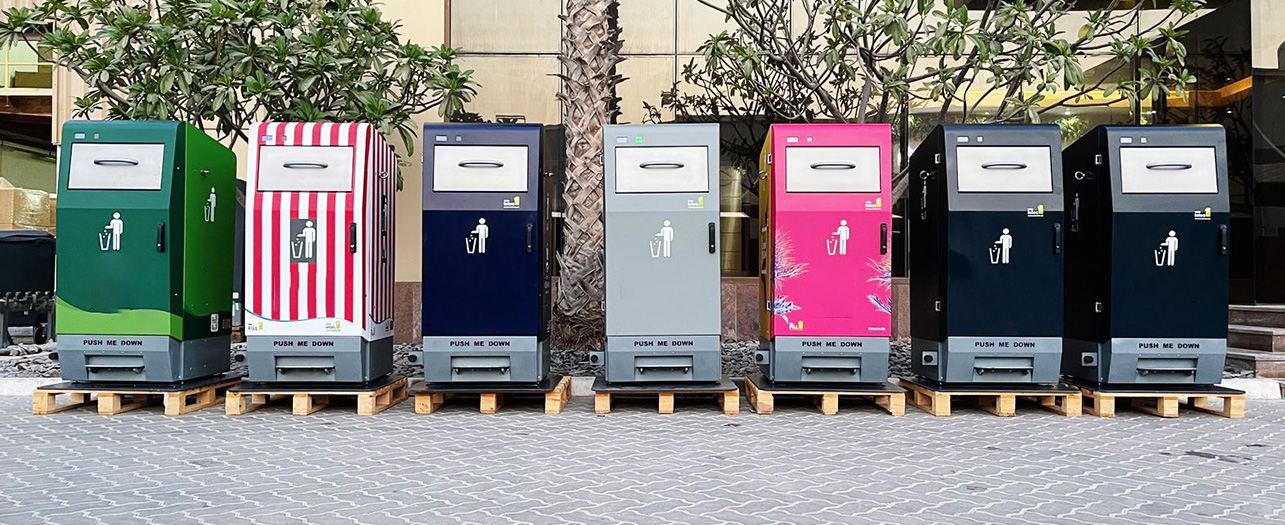 Line of branded smart bins placed on pallets outside a building